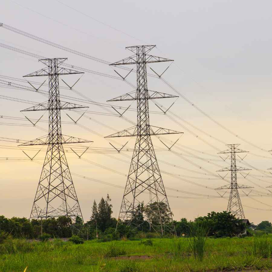 przesyly-slup-wysokiego-napiecia Słupy wysokiego napięcia na zielonej działce – linie energetyczne biegnące nad gruntem<br />